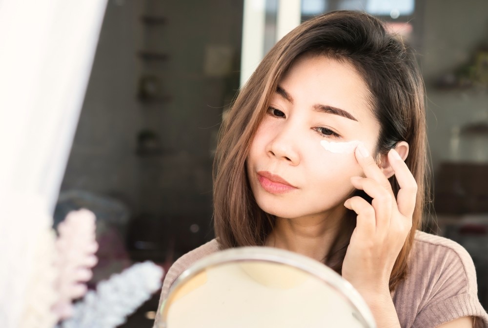 woman applying cream under eye