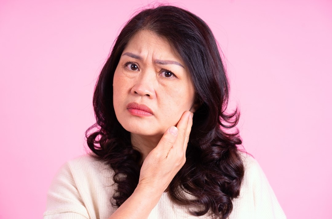 woman looking concerned at her sagging face