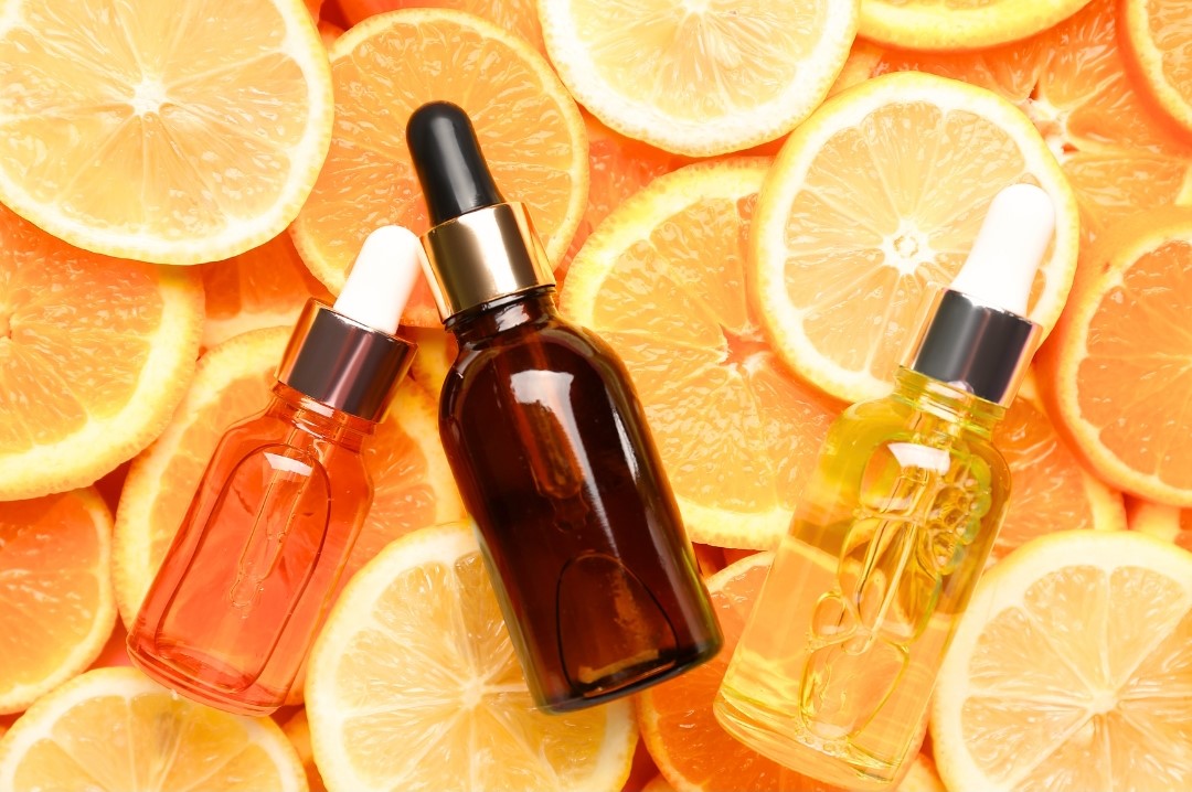 vitamin c serum bottles on orange slices