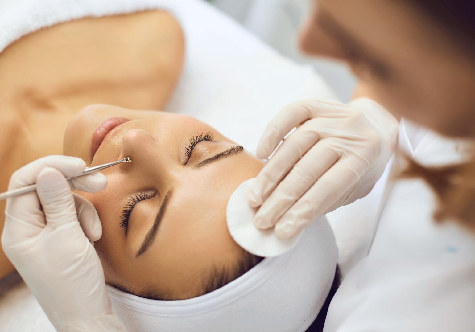 staff clearing acne on customer's nose