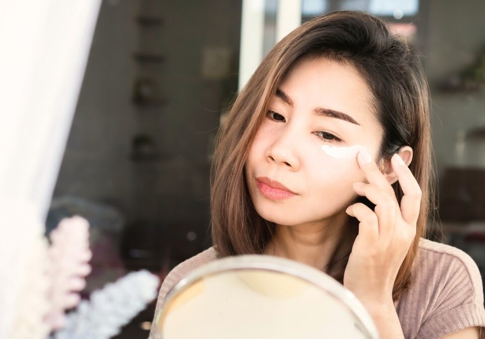 woman applying cream under eye